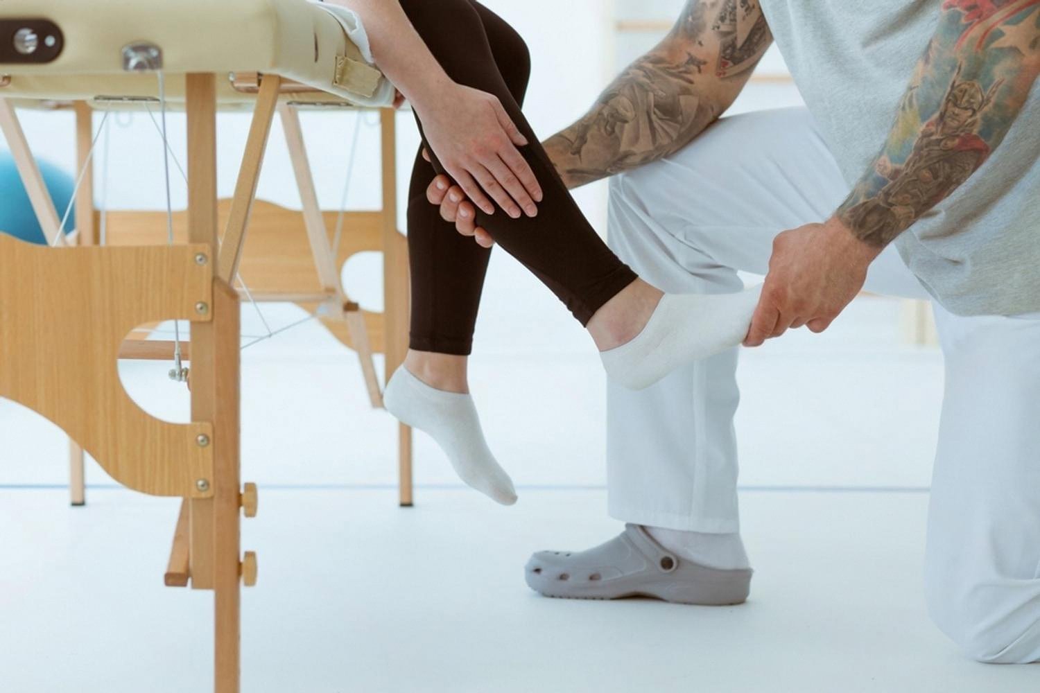 Physiotherapist treating a patient's leg during a rehabilitation session at a UAE clinic
